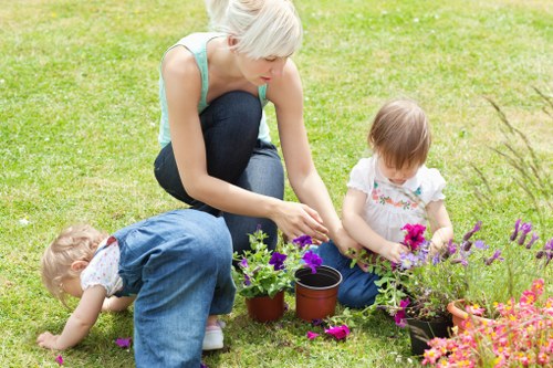Close-up of a gardener pruning a shrub, indicating hands-on garden maintenance in Barnet